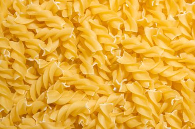 Pişmemiş Fusilli Makarna: Bir Spiral Makarna Mutfağı, Gurme Yemekleri İçin Canlı ve Dokulu Bir Arkaplan Oluşturma. Kuru makarna. Raw Macaroni - Top View, Düz Yat