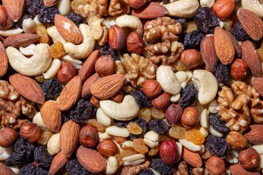 Karışık fındık, badem, ceviz, kaju, fıstık, fındık, kuru erik ve kuru üzüm. Farklı fındık karışımı. Çeşitli Fındık ve Kurutulmuş Meyvelerin Arkaplanı