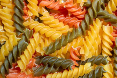Pişmemiş Renkli Fusilli Makarna: Gurme Aşçılığı İçin Canlı ve Dokulu Bir Arkaplan Oluşturan Çok Renklilerden Büyüleyici Mutfak Kanvası. Renkli Kuru Makarna. Çiğ makarna.