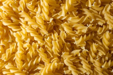 Pişmemiş Fusilli Makarna: Bir Spiral Makarna Mutfağı, Gurme Yemekleri İçin Canlı ve Dokulu Bir Arkaplan Oluşturma. Kuru makarna. Raw Macaroni - Top View, Düz Yat