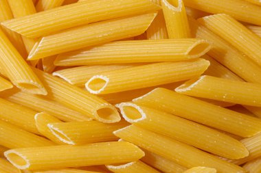 Pişmemiş Penne Rigate Makarnası: Gurme Aşçılık İçin Canlı ve Dokulu Bir Arkaplan Oluşturan Penne Makarna Mutfağı. Kuru makarna. Raw Macaroni - Top View, Düz Yat