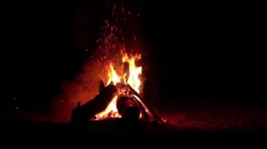 Karanlık Orman 'da Gece Ateşi Yanıyor - Yavaş Hareket. Gece vakti Alevli Kamp Ateşi. Şenlik Ateşi için yer. Ateş Çukuru, Ateş Altında Orman, Uçan Kıvılcımlar ve Duman - Statik Atış