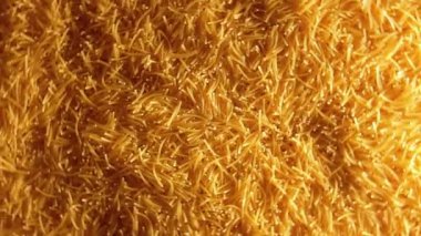 Saat Yönünün Tersinde Dönen Pişmemiş Altın Eriştelerin Arkaplanı - Üst Görünüm Kuru Vermicelli Dönüşü dokusu. Low Key Light ile Çiğ Makarna - Sol Çevirme