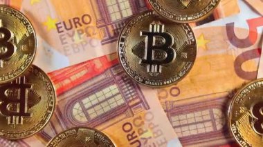 50 Euro 'luk banknotlarda Bitcoin Sikkeleri - Top View. Euro Para Nakiti ve Kripto Para Birimi. Bir sürü 50 Euro 'luk banknot. Ekonomi, Borsa, Engelleme ve Elektronik Para Konsepti - Yavaş Çevirme Sola