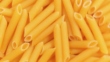 Pişmemiş Penne Rigate Pasta: Penne Macaroni 'nin Mutfak Makarnası, Gurme Yemekleri İçin Canlı ve Dokulu Bir Arkaplan Oluşturma - Üst Görünüm, Döndürme. Kuru makarnaya dönüşüyor. Çiğ makarna - Yan Döndürme