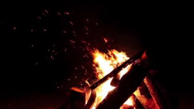 Karanlık Orman 'da Gece Ateşi Yanıyor - Yavaş Hareket. Gece vakti Alevli Kamp Ateşi. Şenlik Ateşi için yer. Ateş Çukuru, Ateş Altında Orman, Uçan Kıvılcımlar ve Duman - Statik Atış