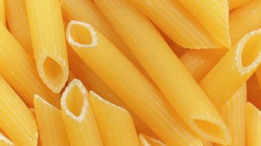 Pişmemiş Penne Rigate Pasta: Penne Macaroni 'nin Mutfak Makarnası, Gurme Yemekleri İçin Canlı ve Dokulu Bir Arkaplan Oluşturma - Üst Görünüm, Döndürme. Kuru makarnaya dönüşüyor. Çiğ makarna - Döndürme