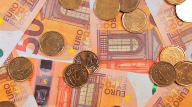 50 Euro 'luk banknotlara 20 Euro Cent madeni parası - Top View. Euro Para Birimi. Turuncu Kağıt Para. Bir sürü 20 Euro 'luk banknot. İş, Finans, Para ve Tasarruf Konsepti - Yavaş Dönüşüm Sola
