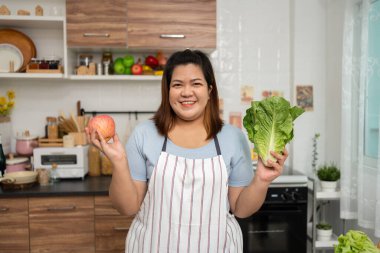 Asyalı Hamile, mutfakta internetten sağlıklı yemek yapmayı öğreniyor, şişman kadınlar diyet yemeği için sebze salatası hazırlıyor ve kilo veriyor. Sağlıklı beslenme kavramı