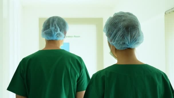 Két Ázsiai Sebész Orvosok Orvosi Maszk Sétál Műtőbe Műanyag Köpenyek — Stock videók