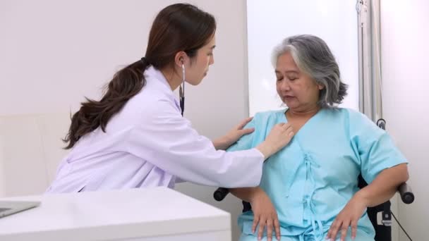 医生用听诊器检查心脏 并在诊所与一名老年妇女交谈 以进行年度检查 药物保健服务和医疗保险概念 — 图库视频影像