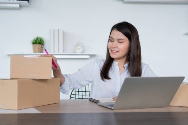 Mutlu Asyalı genç girişimci, Hold paketi ve gülümseme ev ofisindeki çevrimiçi alışveriş mağazasının başarısı, tüccar kavramı, küçük işletme, çevrimiçi ticaret ve eCommerce.