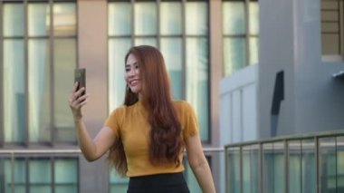 Güzel Asyalı kadın blogcu akıllı telefonu tutuyor ve sosyal ağlarda canlı yayın yapıyor, cep telefonuyla video görüşmeleri yapıyor, neşe selfie 'si, etkili ve iletişim konsepti ile konuşuyor.