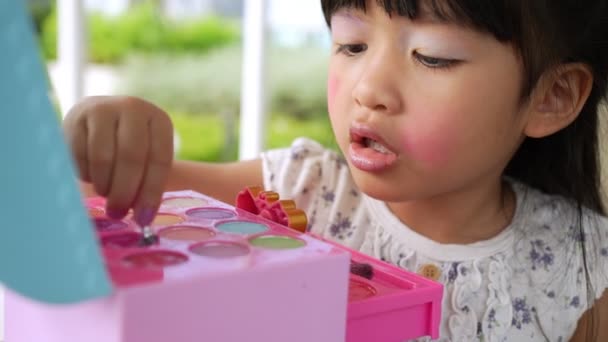 Entzückende Kleine Asiatische Mädchen Malt Ihren Mund Mit Rosa Kinderköpfen — Stockvideo