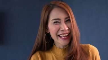 Oturma odasında renkli süveter giyen, kameraya bakıp gülümseyen ve mutlu olan güzel genç bir kadının portresi. Yaz. Kapalı alanda. Yavaş çekim