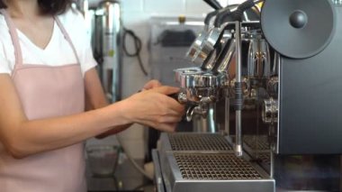 Restoranda ya da kahve dükkanında kahve makinesiyle taze espresso yapan profesyonel bayan baristanın yakın çekimi. Barista Hazırlık veya Girişimci Kahve Makinesi konsepti kendi dükkanında