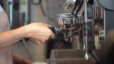 Restoranda ya da kahve dükkanında kahve makinesiyle taze espresso yapan profesyonel bayan baristanın yakın çekimi. Barista Hazırlık veya Girişimci Kahve Makinesi konsepti kendi dükkanında