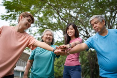 Healthy family group instructors workout in fresh air, and they rest and stand together after morning exercises in park. Outdoor activities, healthy lifestyle, strong bodies, fit figures, health care.