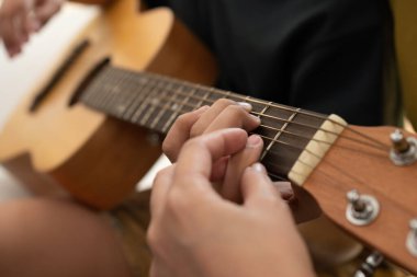 Oğluna gitar çalmayı öğrettiği için annesiyle gitar çalan Asyalı çocuk takdir görüyor ve cesaretlendiriliyor. Mutlu bir aile kavramı, öğrenme ve eğlenceli yaşam tarzı, aile bağlarını sevme