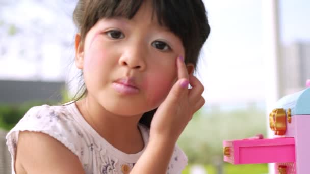 Urocze Dziecko Azjatka Dziewczyna Maluje Usta Różowymi Głowami Dzieci Patrzy — Wideo stockowe