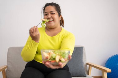 Asyalı Hamile, mutfakta internetten sağlıklı yemek yapmayı öğreniyor, şişman kadınlar diyet yemeği için sebze salatası hazırlıyor ve kilo veriyor. Sağlıklı beslenme kavramı