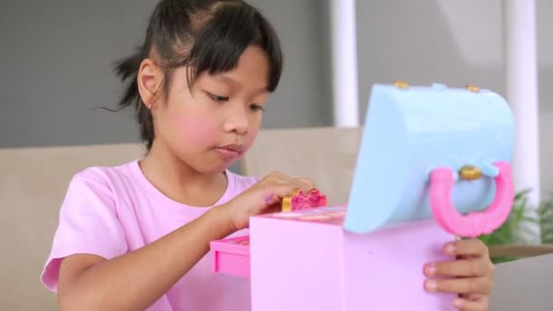 Küçük Sevimli Asyalı Kız Çocuğu Ağzını Pembe Çocuk Kafalarıyla Boyuyor — Stok video