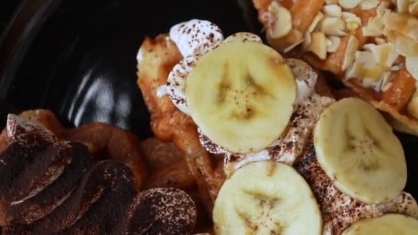 Closeup Top View Rotating Chocolate Powder Cream Banana Almonds Waffles — Vídeos de Stock