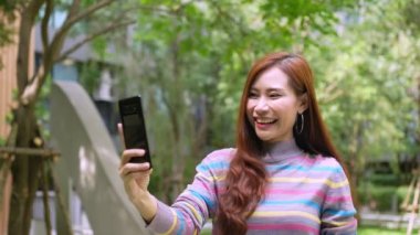Güzel Asyalı kadın blogcu akıllı telefonu tutuyor ve sosyal ağlarda canlı yayın yapıyor, cep telefonuyla video görüşmeleri yapıyor, neşe selfie 'si, etkili ve iletişim konsepti ile konuşuyor.