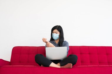 Yüz maskesi takan yorgun bir kadın, bilek ağrısı gergin kaslar, bilgisayarla uzun saatler çalıştıktan sonra ofis sendromu. Ofis sendromu ve sağlık konsepti.