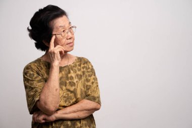 Güçlü kronik baş ağrısı çeken yaşlı bir kadın, eliyle başını tutan bir hasta, bunama, hafıza bozukluğu, kafası karışmış ve Alzheimer hastası.