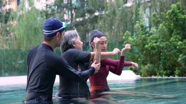 Young Trainer Helping Senior Woman Aqua Aerobics Working Out Pool — Vídeo de stock