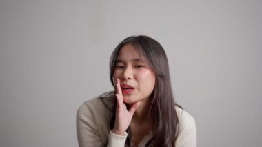 Mutlu genç Asyalı kadın beyaz arka planda izole edilmiş bağırarak el kaldırıyor. Genç bir kadın arkadaşlarına haber veriyor. Dedikodu ve gizlilik kavramı söylentileri yayar.