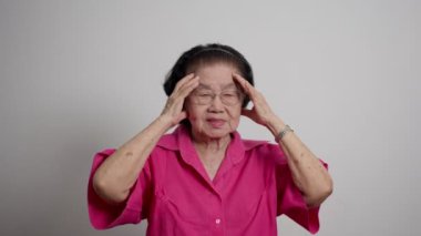 Üzgün, yaşlı, yalnız, olgun bir kadın evdeki kanepede oturuyor. Hasta, olgun bir kadın kendini iyi hissetmiyor, kafasına dokunuyor. Migren ağrısı, yorgunluk, stres konsepti. Depresyon, Alzheimer hafıza kaybı konsepti.