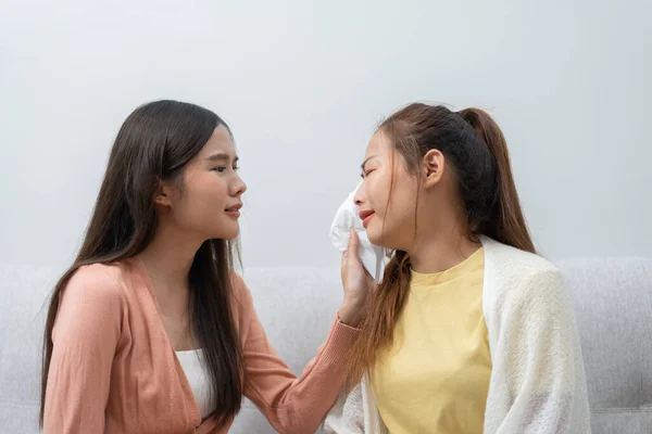 stock image Two women talking about problems at home. Asian women embrace to calm their sad best friends from feeling down. Female friends supporting each other. Problems, friendship, and care concept