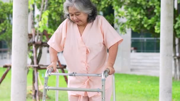 一位快乐的亚洲老年妇女在事故恢复后 使用了一位散步者 走在医院里 快乐退休的概念在照顾者 储蓄和老年健康保险的照料下 — 图库视频影像