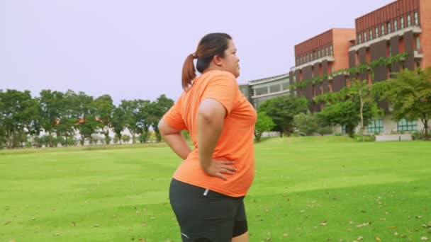 アジアプラスサイズの女性は公園でワークアウトし ジョギング前に筋肉を伸ばす 献身的な緑の公園で屋外で笑顔幸せな陽気な若い肥満の女の子 運動の健康と減量の概念 — ストック動画