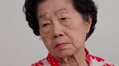 Bunalımlı Asyalı son sınıf öğrencisi kadın, yalnız, beyaz arka planda hayal kırıklığına uğramış ve hafızasını kaybetmiş. Yaşlı kadının portresi hasta depresyon hastalığı üzgün ve mutsuz, bunama, sağlık sorunları konsepti.