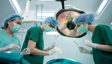 Asyalı Profesyonel Cerrahlar Ekibi ameliyathanede cerrah, asistan ve hemşireler Hasta, sağlık kanseri ve hastalık tedavisi konseptini ameliyat ediyorlar.