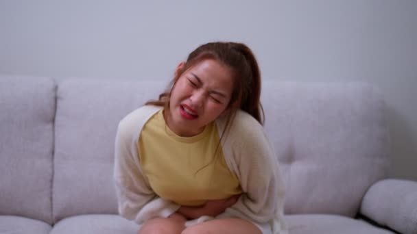 Больной Азиатка Страдает Острой Боли Животе Менструации Пмс Сидя Диване — стоковое видео