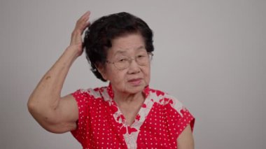 Bunalımlı Asyalı son sınıf öğrencisi kadın, yalnız, beyaz arka planda hayal kırıklığına uğramış ve hafızasını kaybetmiş. Yaşlı kadının portresi hasta depresyon hastalığı üzgün ve mutsuz, bunama, sağlık sorunları konsepti.