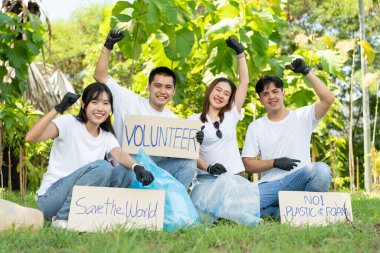 Mutlu Asyalı genç öğrenciler parktaki çöp torbalarıyla çeşitli gönüllüleri, dünya çevre günlerinde çevre koruma kavramını, geri dönüşümü, sürdürülebilirlik için yardım.