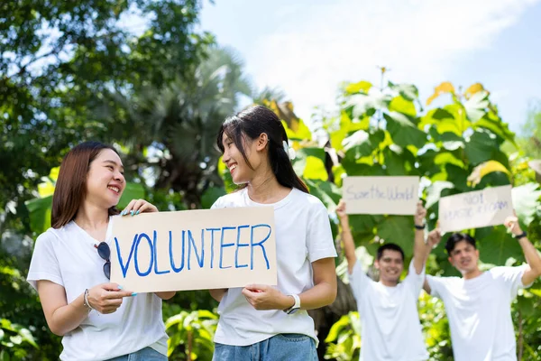 快乐的年轻亚洲学生们 各种各样的志愿者 在公园里举着一个清洁的活动标志 世界环保日 的理念 回收利用 慈善促进可持续性 — 图库照片