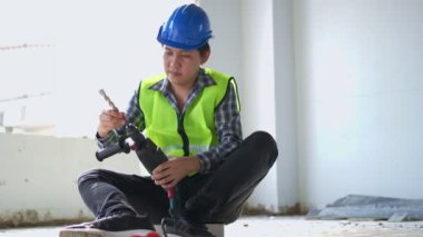 Engineer teaching worker for use electric jackhammer for perforator equipment making holes the floor to be strong at construction site, Concept of worker and residential building