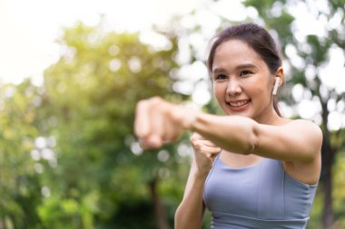 Spor kıyafetli, sıkı bir Asyalı kız spor yapıyor, spor yapıyor ve parkta kardiyo egzersizleri yapıyor. Kız öğrenci boksör motivasyonu.