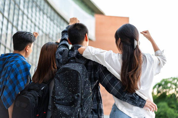 Group of happy young entrepreneurs with hands up and laughing to celebrate and excited success for achievements obtained. Undergraduate students celebrate success after end project, teamwork concept