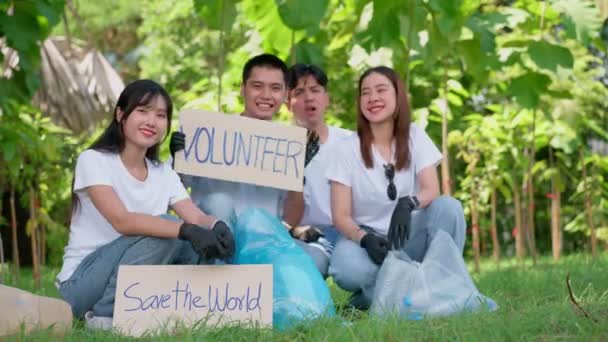 幸せな若いアジアの学生多様なボランティアは 公園内の清掃のためのキャンペーンの兆候を保持します 世界環境デーに環境保全の概念 リサイクル 持続可能性のための慈善団体 — ストック動画