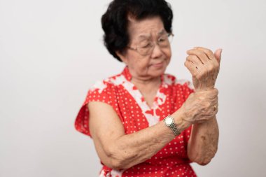 Yaşlı Asyalı kadın hastalar romatizma eklem iltihabından dolayı ellerindeki uyuşma ağrısından muzdarip. Son sınıf öğrencisi kadın bileği ağrıdığı için eline masaj yapıyor. Eklem ağrısı, romatizma eklem iltihabı ve el sorunları..
