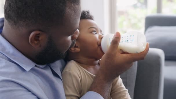 Africký Otec Sedí Pohovce Drží Krmí Novorozeně Lahvového Mléka Obývacím — Stock video