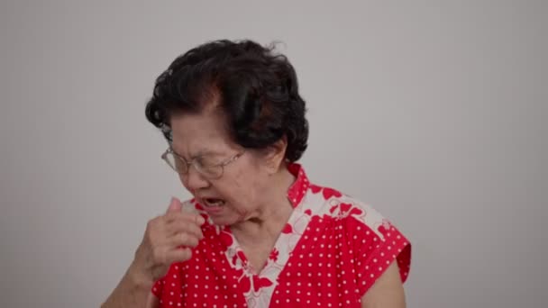 一位年长的亚洲女人由于对空气过敏和大量灰尘而鼻塞 一位年长的女人吹鼻涕 老太太得了感冒或流感 感到悲伤 流鼻涕 — 图库视频影像