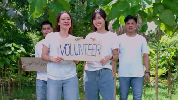 幸せな若いアジアの学生多様なボランティアは 公園内の清掃のためのキャンペーンの兆候を保持します 世界環境デーに環境保全の概念 リサイクル 持続可能性のための慈善団体 — ストック動画